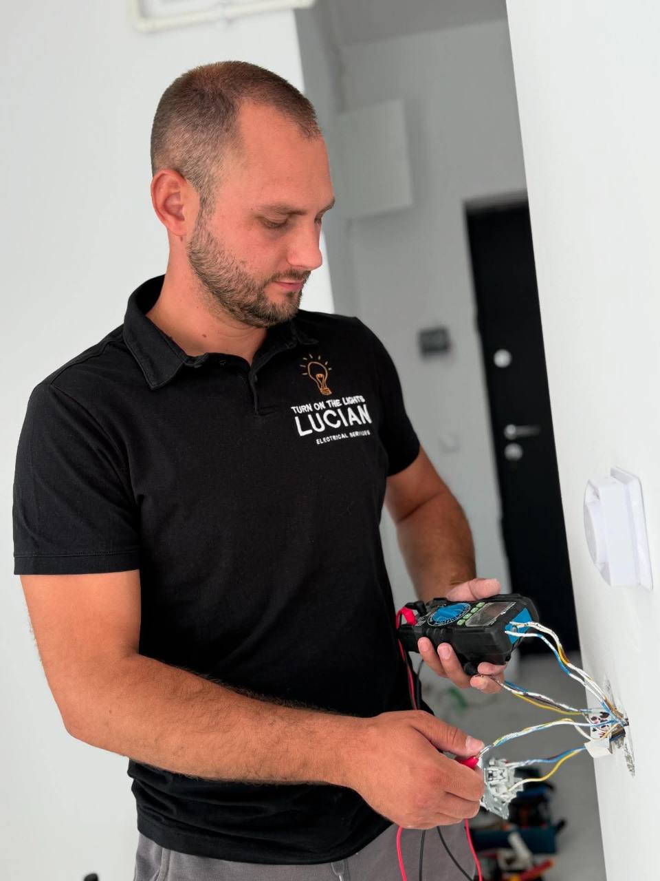 Lucian în timpul unei lucrări electrice, folosind un aparat de măsură